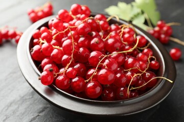 Fresh red currants and green leaves on dark grey table, closeup © New Africa
