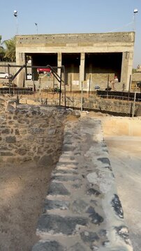 Restoration work on ancient stone ruins alongside new construction at a heritage site.