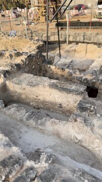 Ancient stone foundations at an active archaeological excavation and restoration site.