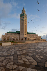 Obraz premium Morning in Casablanca, Morocco. Beautiful Hassan II Mosque surrounded by birds just after sunrise. The Beautiful mosque is one of the highlights of Moroccan culture. 