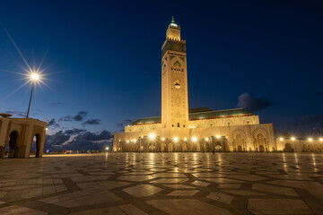 Fototapeta premium Beautiful Hassan II Mosque lit but starburst shaped lights in the evening in blue hour, in Casablance, Morocco. Amazing site. 