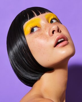 Woman with black bob and yellow eyeshadow