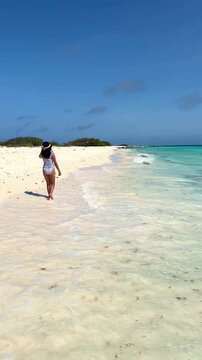 Woman walking on a tropical Caribbean beach in Klein Curacao