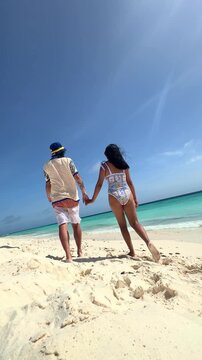 Romantic couple holding hands walking on Klein Cura&ccedil;ao beach