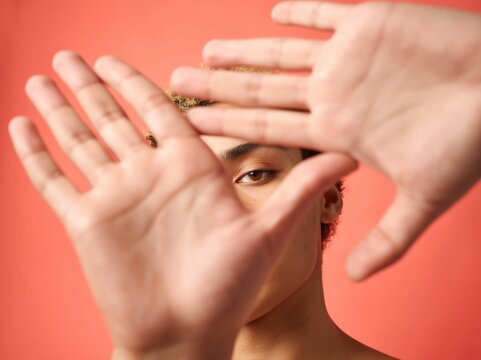 Young person looking through hands framing face portrait