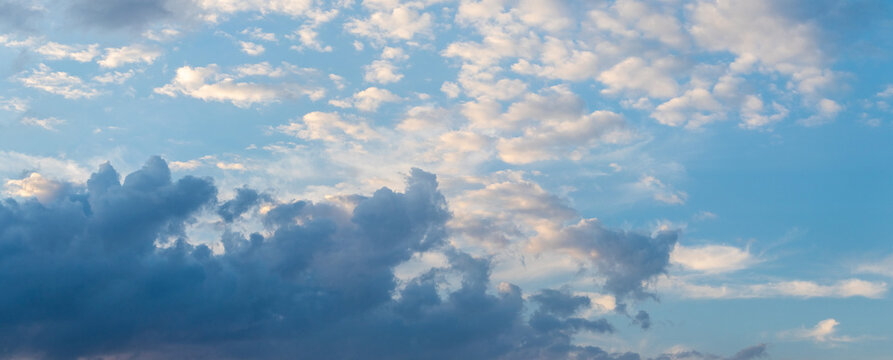 Panoramic blue sky with small clouds and dark cloud on horizon