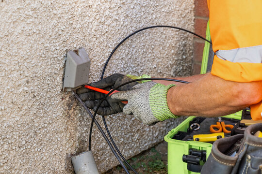 Engineer removing external fibre termination box cover with screwdriver