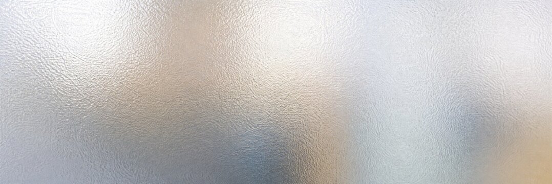 Frosted glass texture with soft light bokeh, blurred window background with matte finish, abstract silver and white glass surface for privacy design and professional corporate overlays.