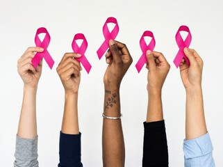 Fototapeta premium Diverse Group of Diverse Women Hands Raised Holding Pink Ribbons for Breast Cancer Awareness Mont
