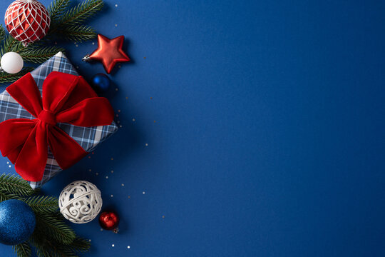 Merry Christmas and Happy New Year gift with red bow and ornaments on blue background
