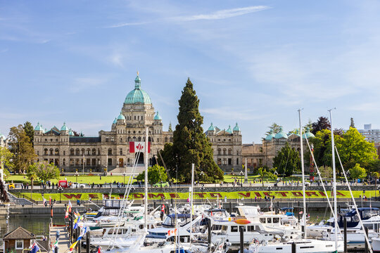 June 5, 2025 - Victoria, BC, Canada: Legislative Assembly of British Columbia in downtown Victoria over the harbor with "Welcome to Victoria" in the landscaping.