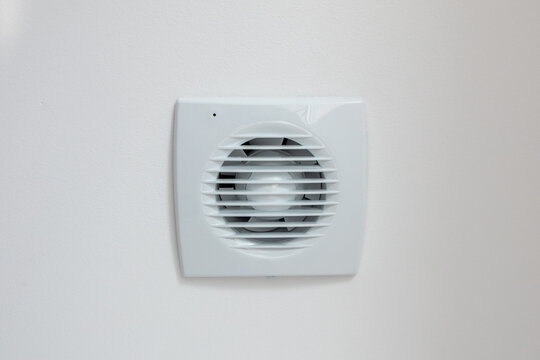 Modern white ventilation fan mounted on a textured wall