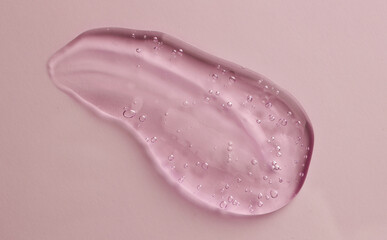 Fototapeta premium Smear of pink cosmetic gel on color background, top view