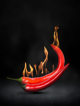 Hot chili peppers with flames on black background