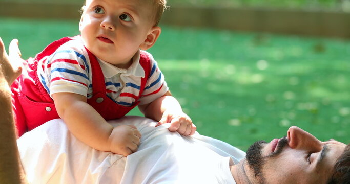 Candid casual father and baby son interaction relationship lifting child hugging