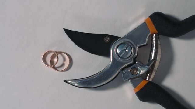 Idea of relationship breakup through rings and metal shears conveys divorce