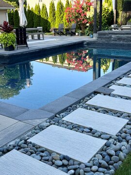 Gorgeous country cottage style border garden in among a modern, sleek, luxury outdoor patio living space equipped with a pavilion, pergola, cabana, pool, chaise lounge, fire pit, hot tub, sofa.