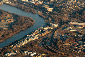 Obraz premium Aerial view of the James River and Rockett's Landing riverfront development near downtown Richmond, Virginia, with active rail lines, warehouses, and a historic water tower