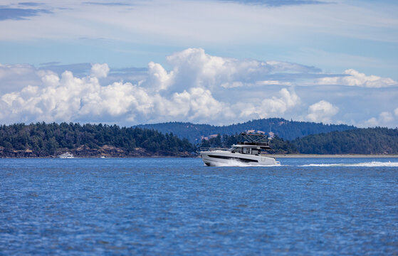 Motor Yacht Cruising Along Coastal Waters Near Sidney With Dramatic Cloudscape Over Vancouver Island
