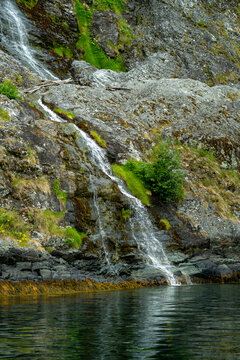 Small stream trickling down a mossy grey rocky cliff face