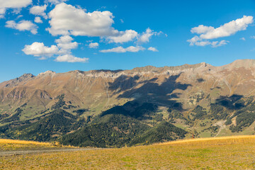Fototapeta premium Horizontal sunny alpine mountain landscape with blue sky and clouds in Arkhyz Karachay Cherkessia Russia.