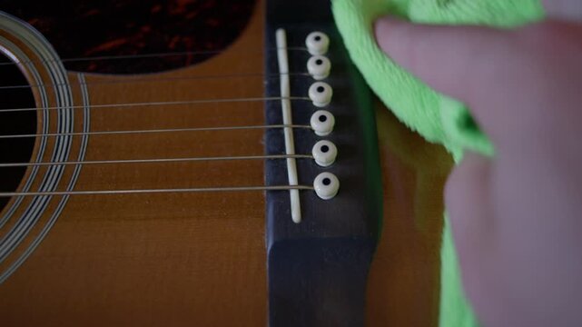 Luthier Wiping Acoustic Guitar Body with Microfiber Cloth During Maintenance Shot with Cinema Camera