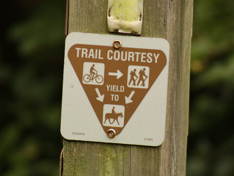 Sign on a trail about trail courtesy about who should yield to who.