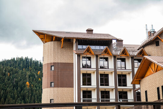 Horizontal view of alpine hotel buildings with balconies in Arkhyz mountain resort.