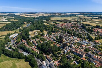 Aerial panoramic view of Pickering North Yorkshire featuring the historic Pickering Castle the North Yorkshire Moors Railway residential neighbourhoods and surrounding patchwork farmland © Duncan