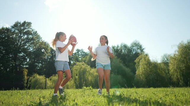 Happy family Children throw outdoors. Sisters play ball in park, enjoying sunny day. family time with ball games. Children throwing ball smiling active. Happy family ball fun nature. Family throw joy.