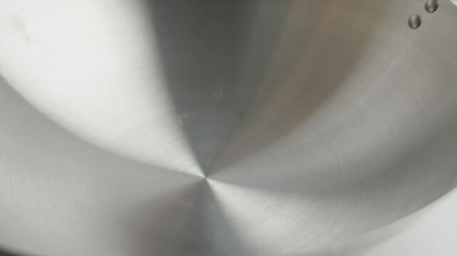 Close-up of a creamy white liquid being poured onto a smooth surface, creating a flowing circular pattern. Detailed food and agricultural production process with a clean minimal appearance. Useful for