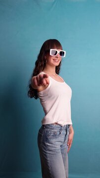 Fashionable young woman pointing finger wearing sunglasses