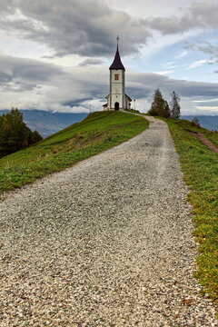 St.Primus and Felician hilltop Gothic church on a grassy ridge backed by the Karavanke mountains, on a cloudy autumn afternoon. Jamnik-Slovenia-169