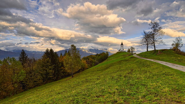 St.Primus and Felician hilltop Gothic church on a grassy ridge backed by the Karavanke mountains, on a cloudy autumn afternoon. Jamnik-Slovenia-172
