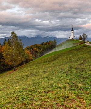 St.Primus and Felician hilltop Gothic church on a grassy ridge backed by the Karavanke mountains, on a cloudy autumn afternoon. Jamnik-Slovenia-175