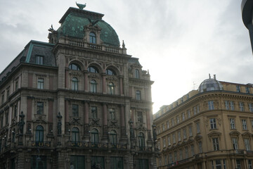 Fototapeta premium Ornate historic buildings with green copper dome against bright sky
