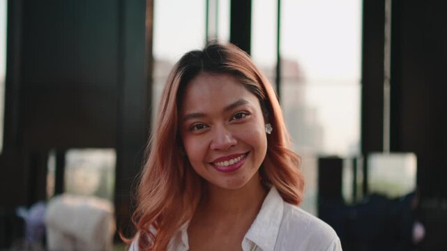 Beautiful young woman with dyed hair smiling at the camera on a rooftop terrace