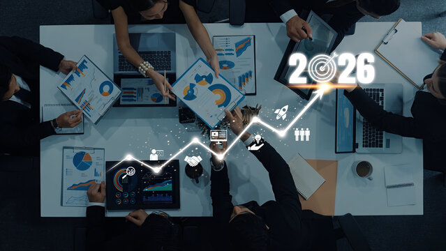 A dynamic business team engages in a productive meeting showcasing digital charts and graphs while focusing on future goals set for 2026 and financial growth. Trope