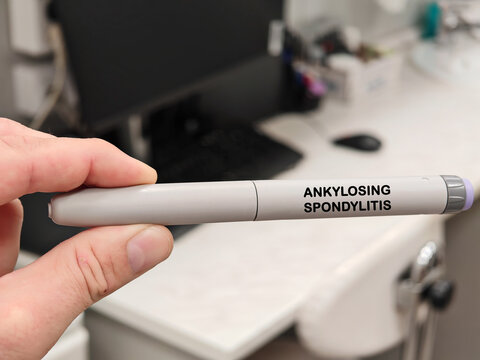 ANKYLOSING SPONDYLITIS medical concept with an autoinjector in pharmaceutical research laboratory