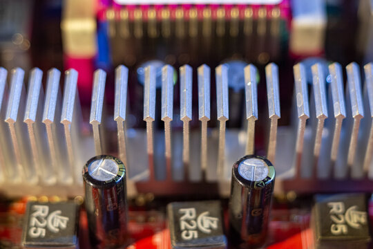 Aluminum heatsink on computer motherboard with electronic components and capacitors