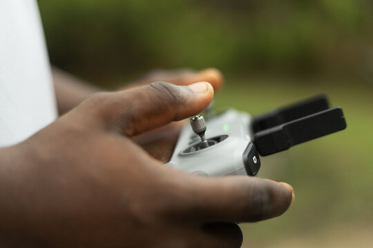 Hands operating the remote of a drone device