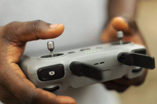 Hands operating the remote of a drone device