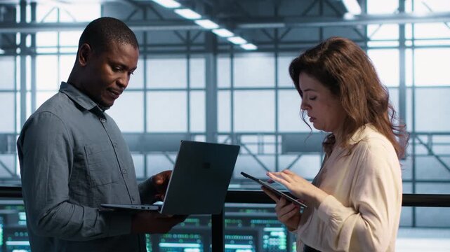Software developers use laptop and tablet in a server farm to perform vulnerability scans and verify firewall security, combining vulnerability scanning, security patch and firewall security.