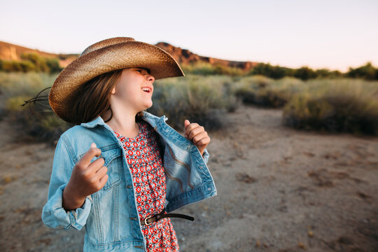 Laughing Little Girl in Cowboy Hat and Denim Jacket in Arizona Desert