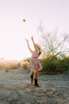 Little Girl Playing at Sunset in the Arizona Desert With an Orange