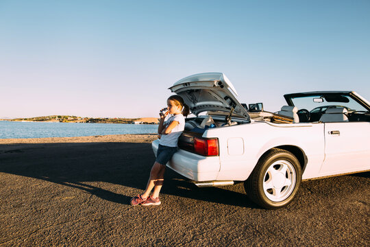 Little Girl Drinking a Soda Beside a Convertible at Lake Pleasant, Arizona