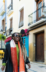 Obraz premium Stylish black woman enjoying urban stroll with vibrant scarf