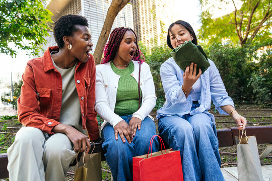 Female friend group reacting to surprise gift outdoors