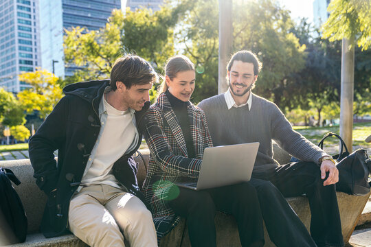 Coworking business team using laptop in city park