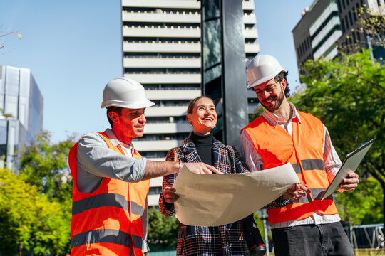 City coworking team reviewing construction plan outdoors